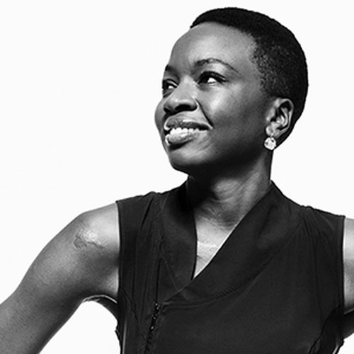 Black and white portrait of playwright Danai Gurira, a black female wearing a black dress.